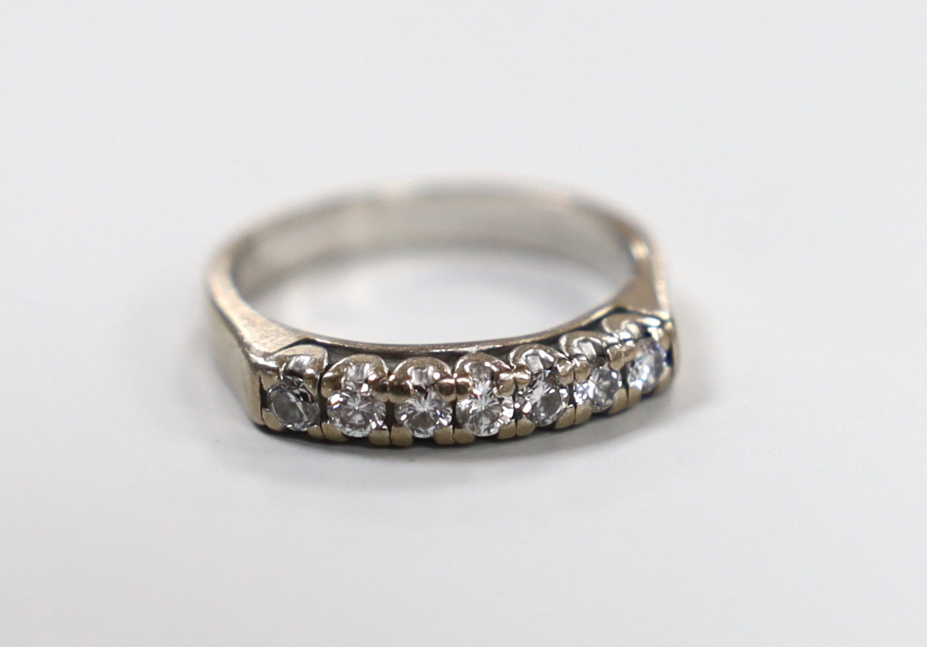 A modern white metal and seven stone diamond set half eternity ring, size L/M, gross weight 4.2 grams.